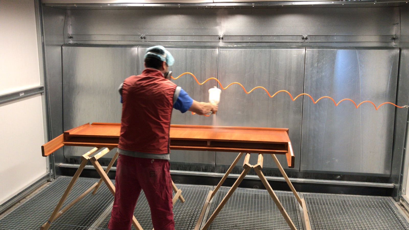 Operator painting in front of an ALWO W open-face water-curtain spray booth